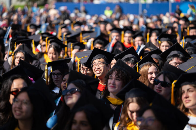 University of Rochester graduates sit among the crowd during the Commencement Weekend ceremony.
