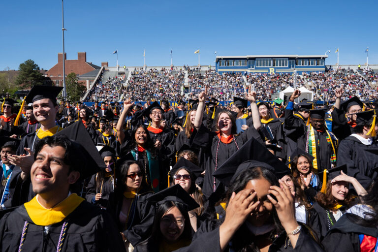 A University of Rochester graduate waves from the crowd during Commencement Weekend.