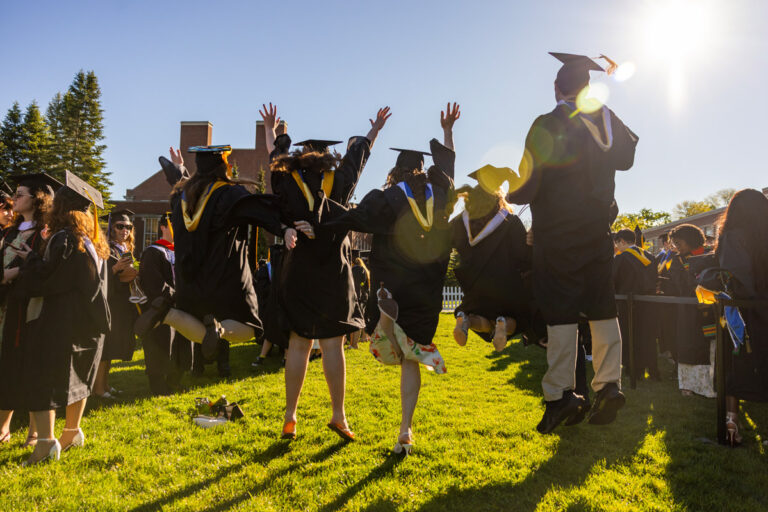 University of Rochester graduates jump in celebration on the grass during Commencement Weekend.