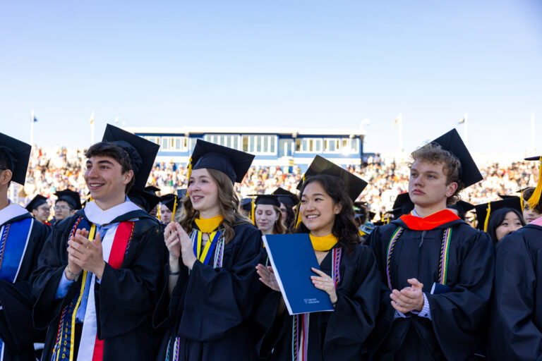University of Rochester graduates applaud during the Commencement Weekend ceremony at Fauver Stadium.