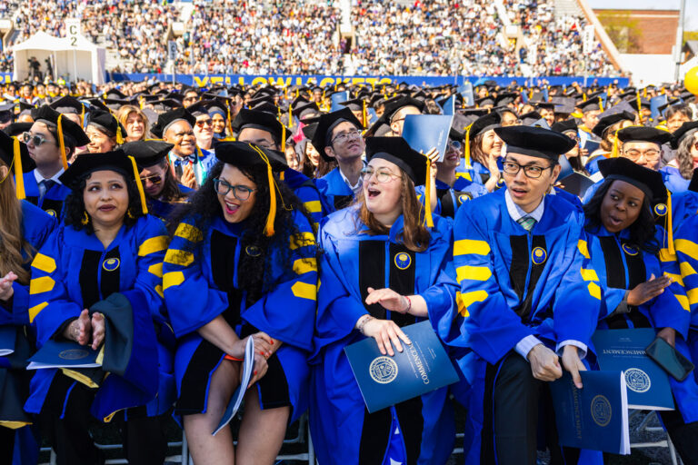 University of Rochester graduates in blue doctoral regalia react during the Commencement Weekend ceremony.