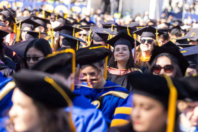 University of Rochester graduates sit among a large crowd during the Commencement Weekend ceremony.
