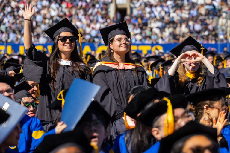 University of Rochester graduates wave and cheer during the Commencement Weekend ceremony.