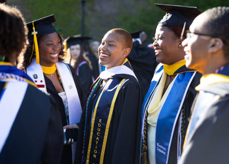 University of Rochester graduates laugh together before the Commencement Weekend ceremony.