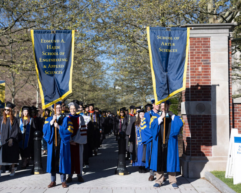 University of Rochester faculty carry school banners during the Commencement Weekend procession.