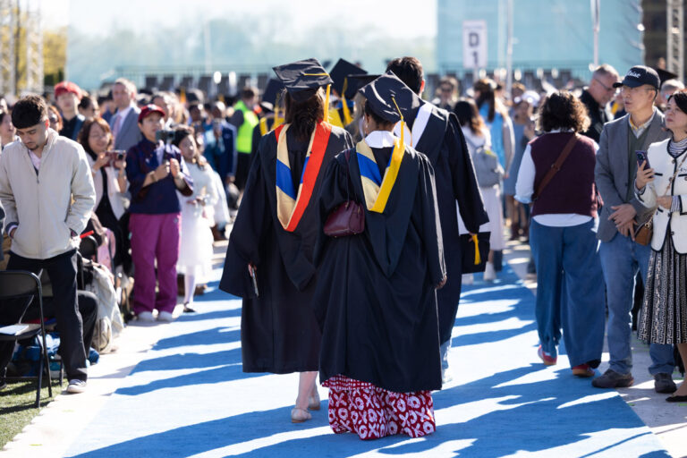 University of Rochester graduates walk down the blue carpet during Commencement Weekend.