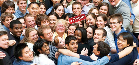 A large group of students hugs Dottie Welch.
