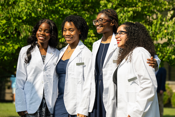 Muosekalo Ituah, Angel Ugu-Nwauwa, Briana Boachie and Sara Marcos pose for a photo after the white coat ceremony