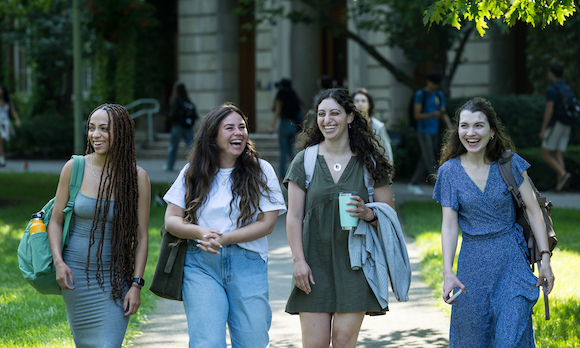 four students walk to class on a fall day