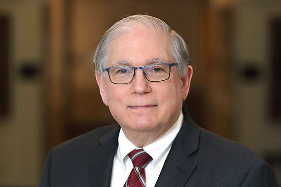 Close-up headshot of Larry Tabak wearing a suit.