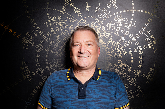 Stu Elby stands in front of a visual map of stereographic projection.
