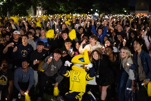 Mascot Rocky surrounded by students on Eastman Quadrangle.