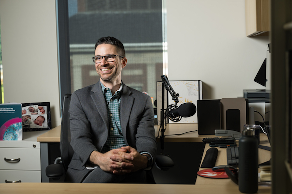 Darren Lipomi, Professor of Chemical Engineering and chair of the Department of Chemical Engineering photographed in his office near a podcasting microphone