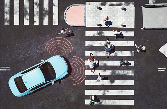 Overhead view of a vehicle with sensors activated while turning into a crosswalk with people to illustrate the concept of improved autonomous machines.