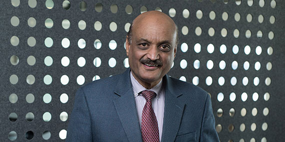 A headshot of Bhaskar Pant in front of a gray background with white dots.