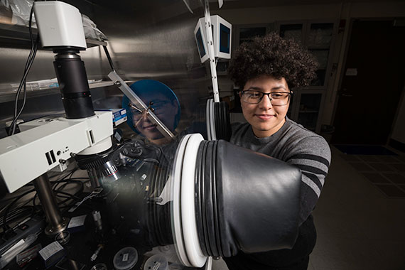 A student in a lab with an electromagnetic generator.
