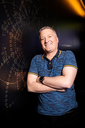 Stu Elby stands in front of a visual map of stereographic projection.