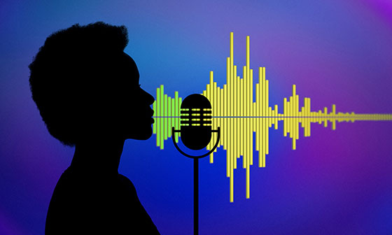 Silhouette of a person in profile speaking into a microphone with their sound waves changing in color, size, and intensity as they go through the microphone.