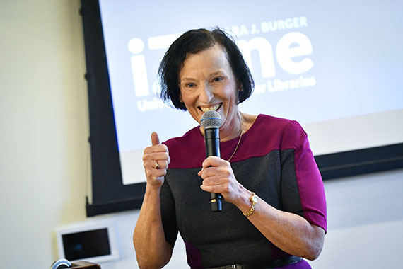 Barbara Burger gives a thumbs up while speaking into a microphone at the iZone.