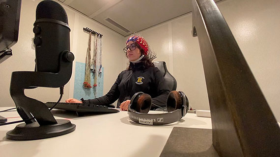 A person wearing an electroencephalography cap uses a computer.