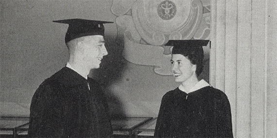 A black and white photo of Rick and Barbara Zuegel modeling their graduation regalia in 1957.