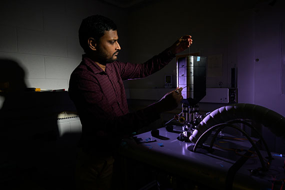 University of Rochester graduate student adjusts a confocal microscope in an optics lab.