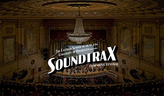 An orchestra performing at Kodak Hall at Eastman Theatre with a logo overlaid on top that says "The Eastman School of Music at the University of Rochester presents SoundtraX Film Music Festival."