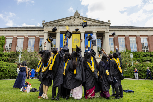Graduates throw their caps in the air. 