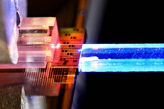 Close-up of a photonic chip coupled to a highly nonlinear crystal and a fiber array unit.