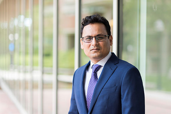 A medium shot of Ehsan Hoque standing in front of Wegmans Hall.