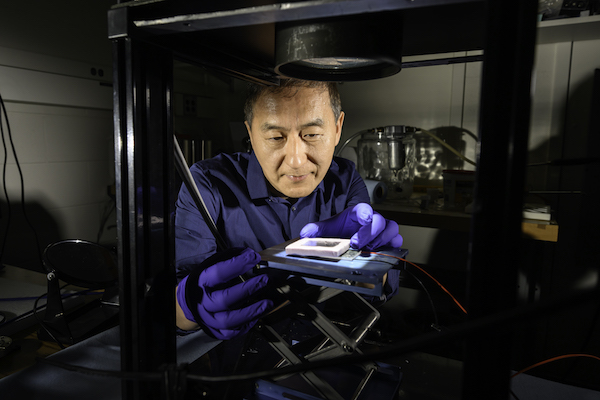 Chunlei Guo uses a source of simulated sunlight to test the absorption of a solar thermoelectric generator created in his lab.