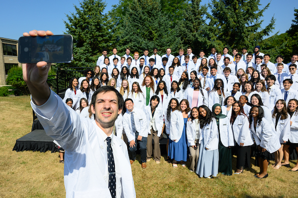 Joshua Coan takes the class selfie after the Class of 2029 White Coat Ceremony. 