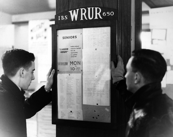 Students look at the WRUR bulletin board. 