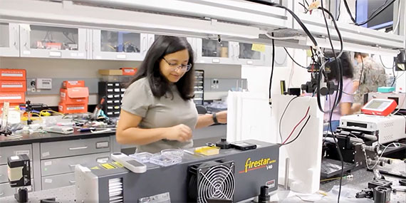 Juniyali Nauriyal adjusts optical experiments on an optical bench in the lab of Associate Professor Jaime Cardenas.
