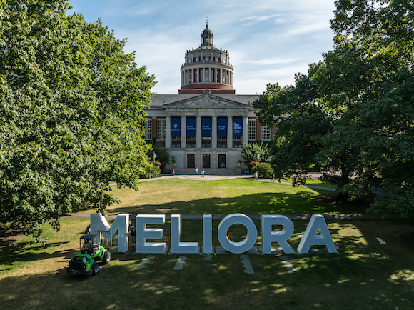 Workers assemble Meliora letters on Eastman Quad.