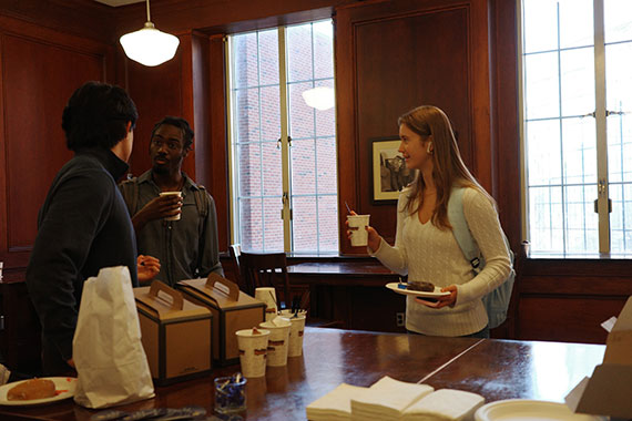Students chat while getting coffee and donuts.
