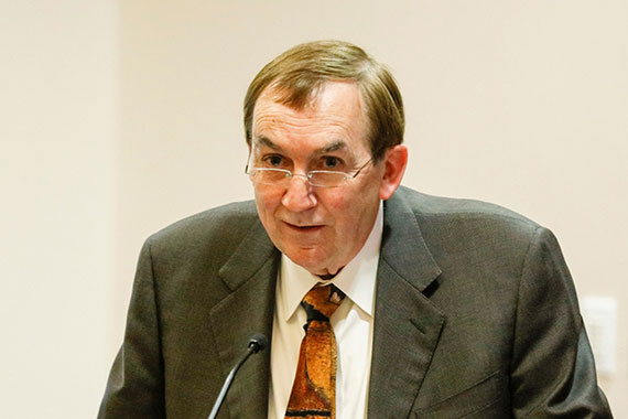 Professor Emeritus Duncan Moore speaks at a lectern.