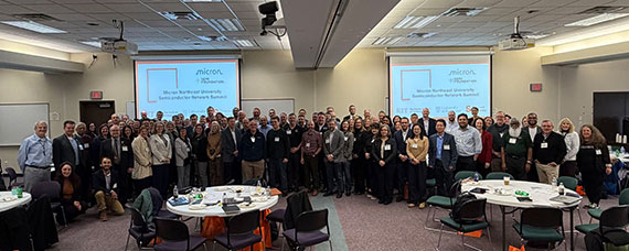 Dozens of people pose for a photo in Slaughter Hall on the RIT campus.