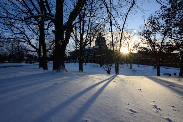 Rush Rhees Library seen in the afternoon after a light snowfall.