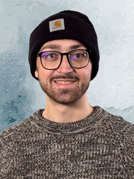 Headshot of a man in a black winter cap and grey sweater. 