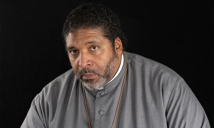 Headshot of a man in a grey garment. 