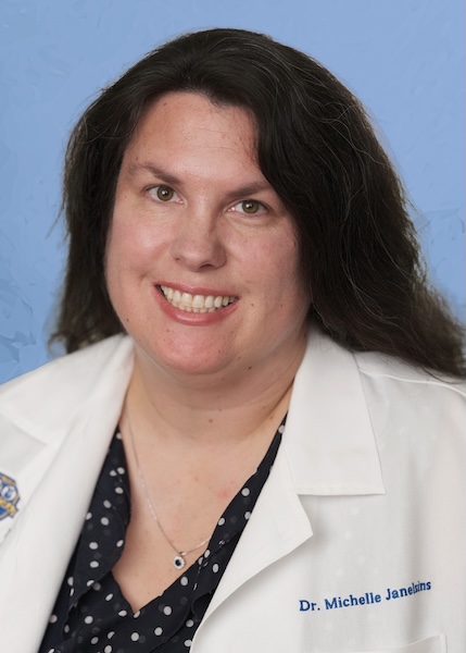 Headshot of a female doctor in a white lab coat. 