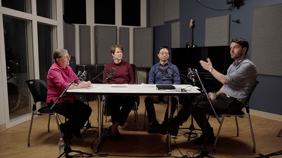 The four principal investigators of the TEAMuP project have a discussion around a table in an audio recording studio.