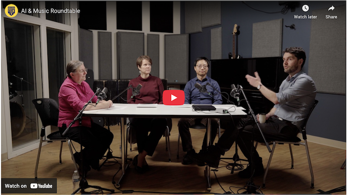 Screenshot of a YouTube page showing four faculty members sitting around a table with recording equipment. 