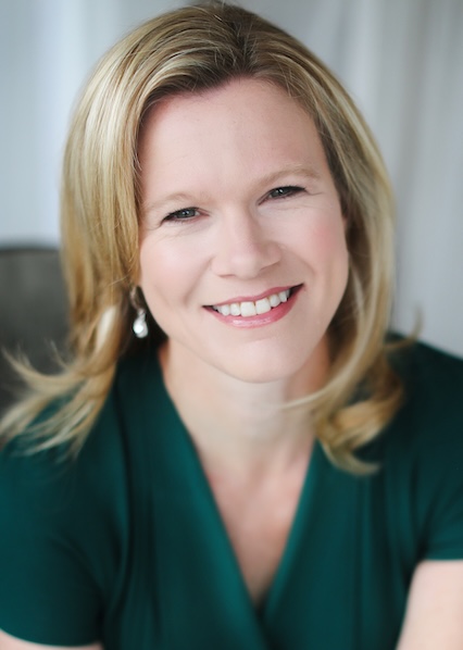 Headshot of a blonde woman wearing a green top. 