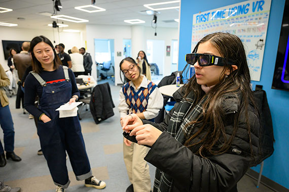 A person gestures while using Snap Spectacles augmented reality headset and others look on.