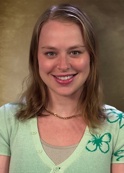 Headshot of a woman with shoulder-length blond hair wearing a green top. 