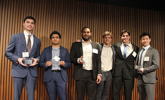 Six students wearing suits hold up awards at the New York Business Plan Competition.