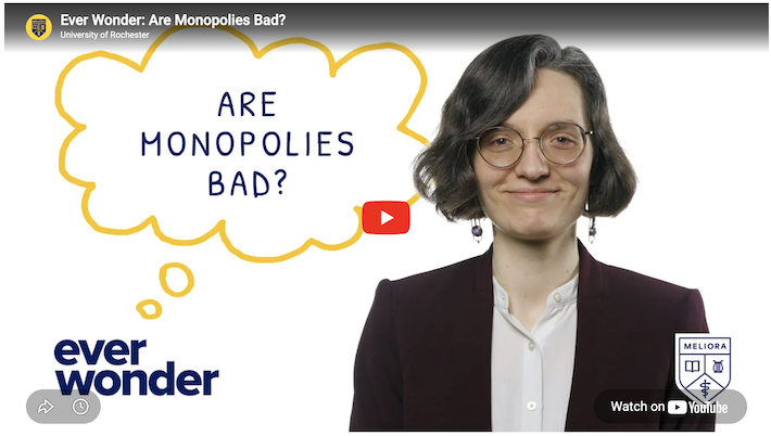 YouTube video screen with a professor in a white button-down shirt and maroon blazer. A thought bubble reads: Are monopolies bad?