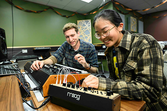 Alumnus Rick Carl and a URochester graduate student manipulate a Moog synthesizer.